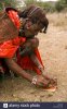 maasai-warrior-crushing-stone-for-face-paint-maji-moto-maasai-village-BBY529.jpg